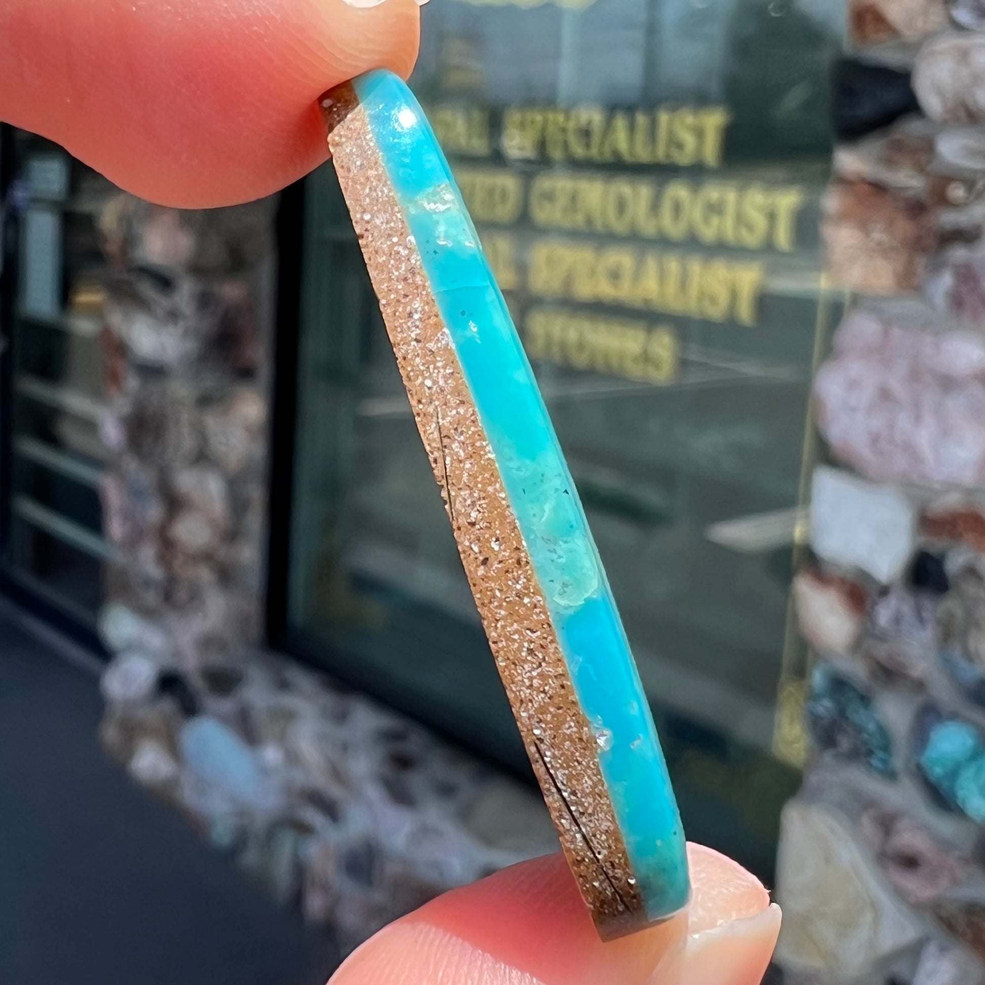 A loose, pear shaped Morenci turquoise cabochon.  The stone has pyrite inclusions.