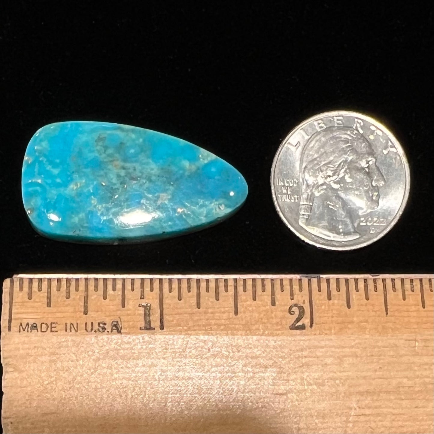 A loose, pear shaped Morenci turquoise cabochon.  The stone has pyrite inclusions.