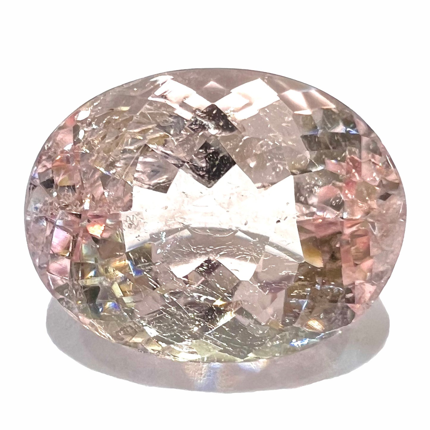 A loose, faceted oval cut pink morganite stone weighing 14.84 carats.