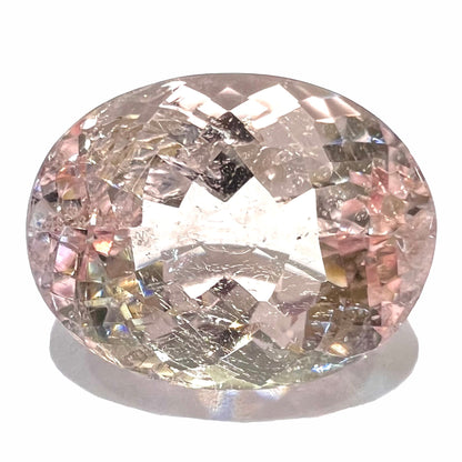 A loose, faceted oval cut pink morganite stone weighing 14.84 carats.