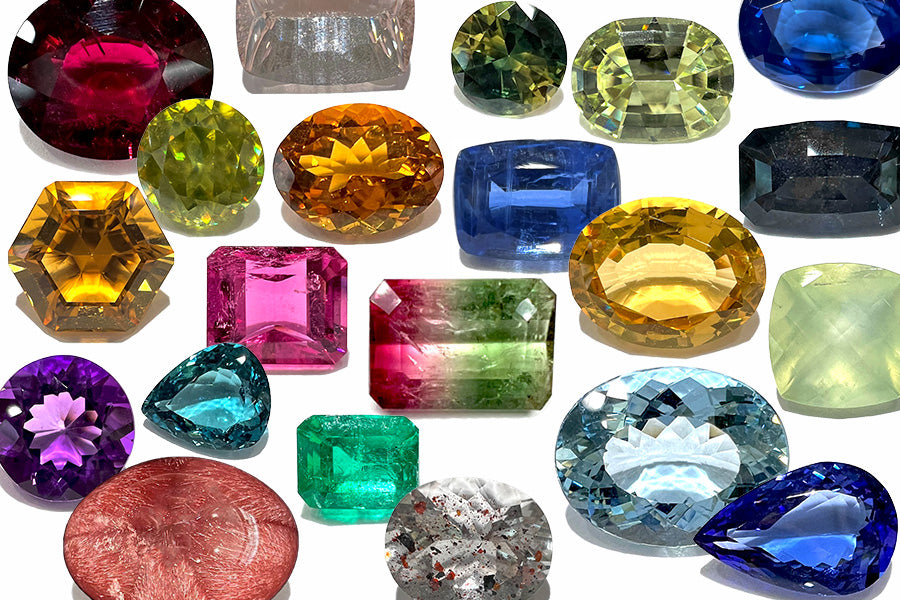 A colorful collection of natural loose gemstones.  Pictured are sapphires, emerald, tanzanite, watermelon tourmaline, different varieties of quartz, and more.