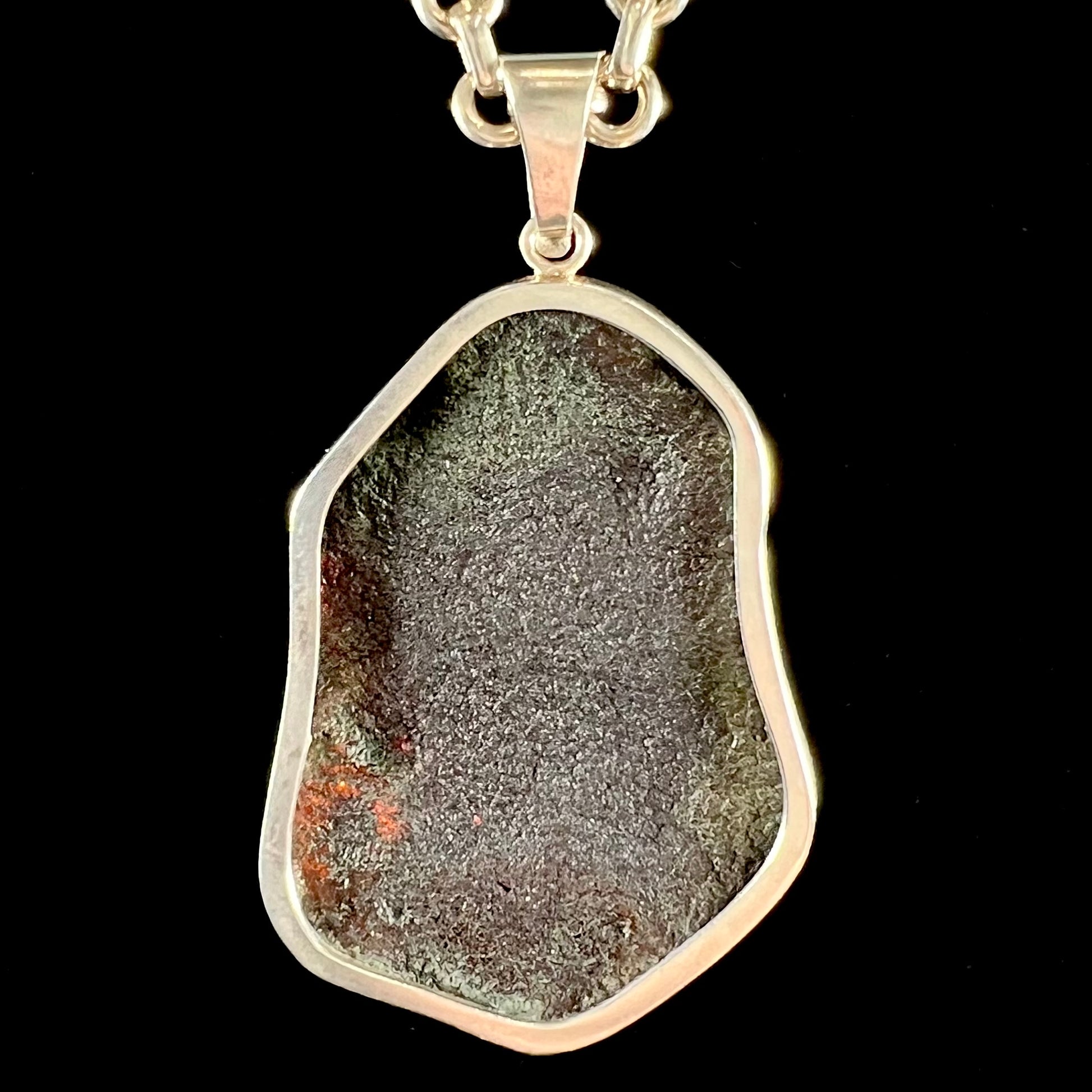 A sterling silver pendant set with a large natural amber stone.  The amber has sun spangled inclusions.