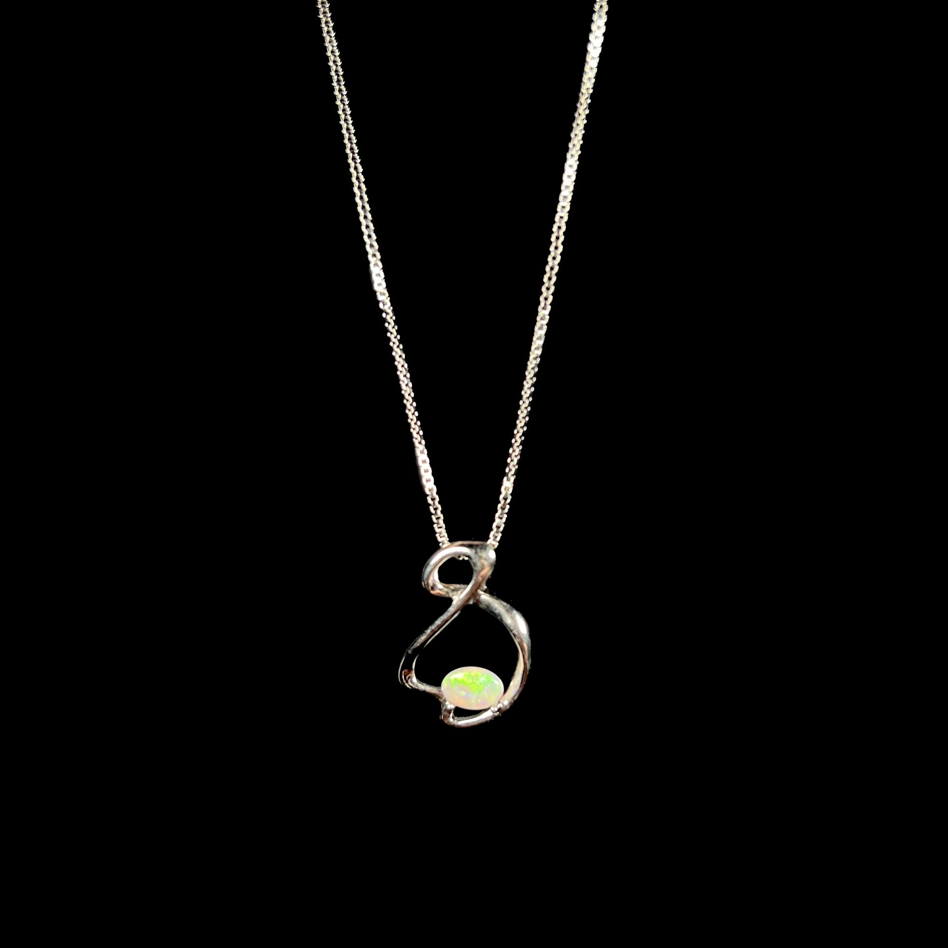 A ladies' sterling silver necklace set with an oval cabochon cut natural white crystal opal with green fire.