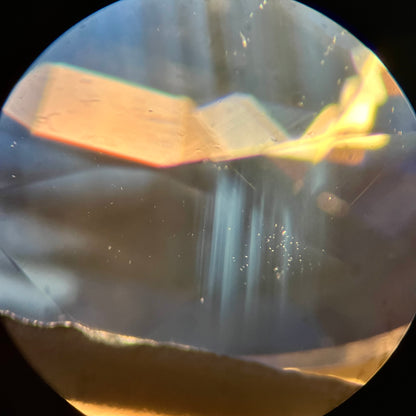 A natural blue sapphire under 45x magnification exhibiting a cloud of heat treated rutile inclusions.