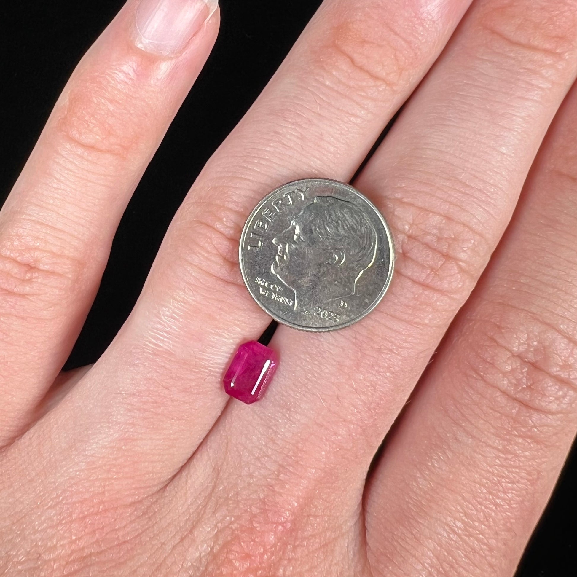 A natural, emerald cut Burma ruby with a purplish pinkish red color.