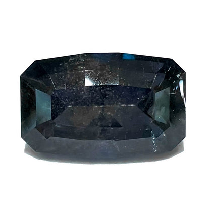 A loose, modified emerald cut, natural color change sapphire stone.  The stone shifts from black to blue to purple to green.