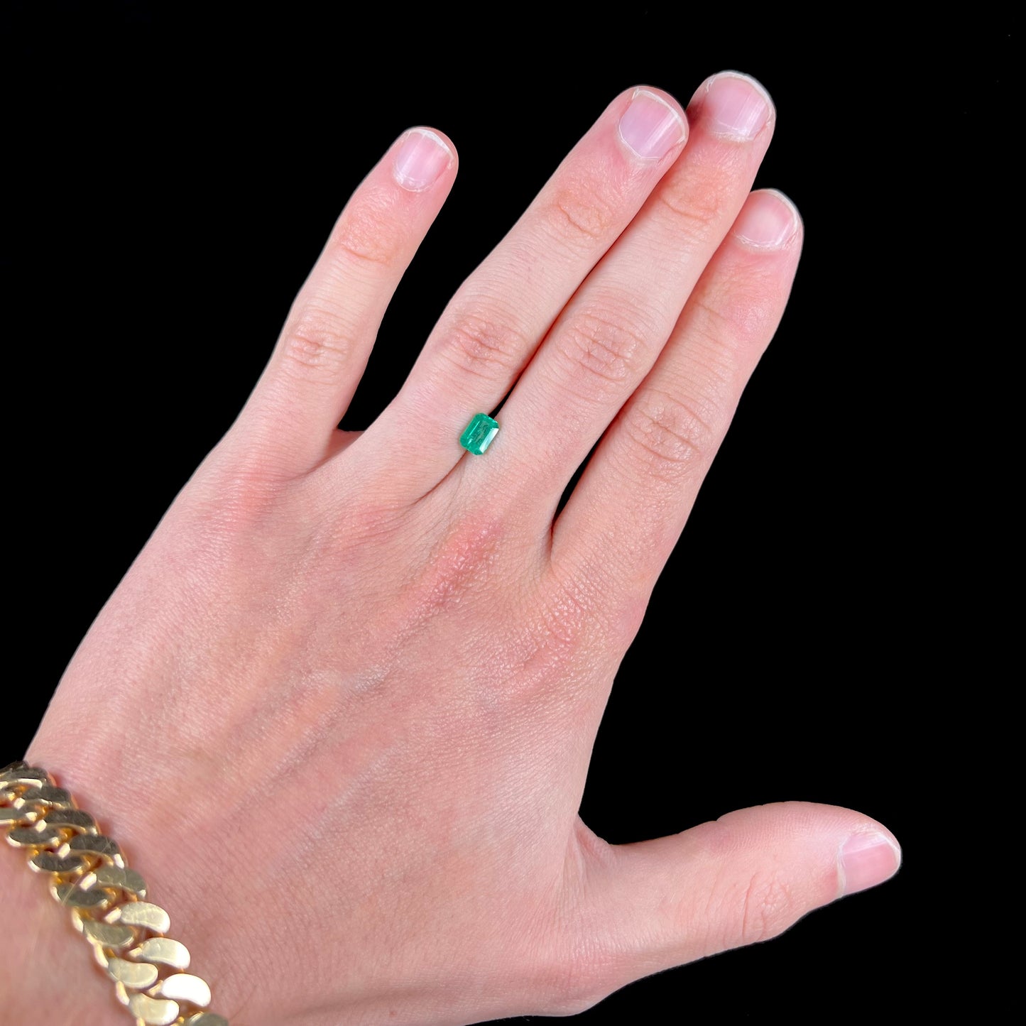 A loose, natural emerald gemstone.  The stone is emerald cut.