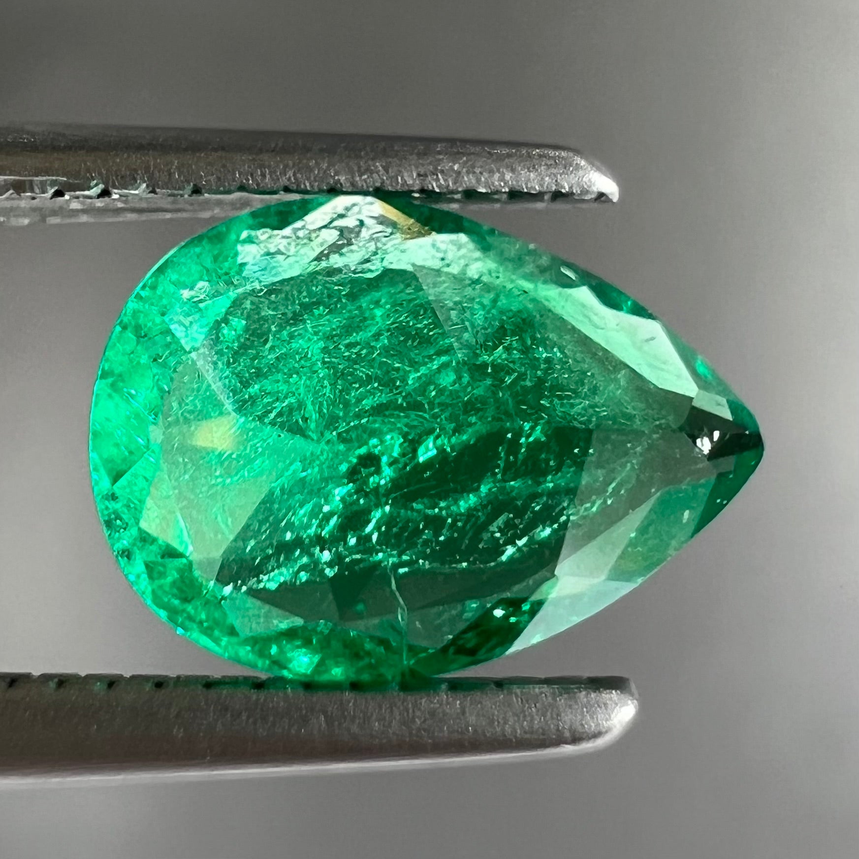 A loose, pear shaped natural emerald gemstone.