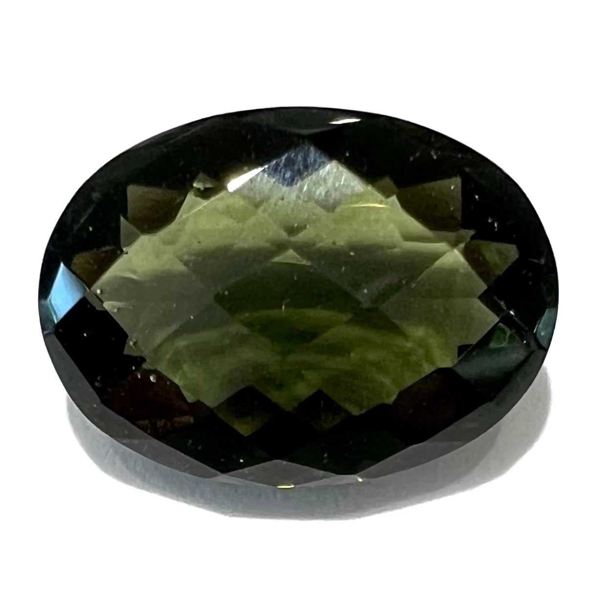 A faceted oval cut natural moldavite gemstone.  The stone weighs 4.53 carats.