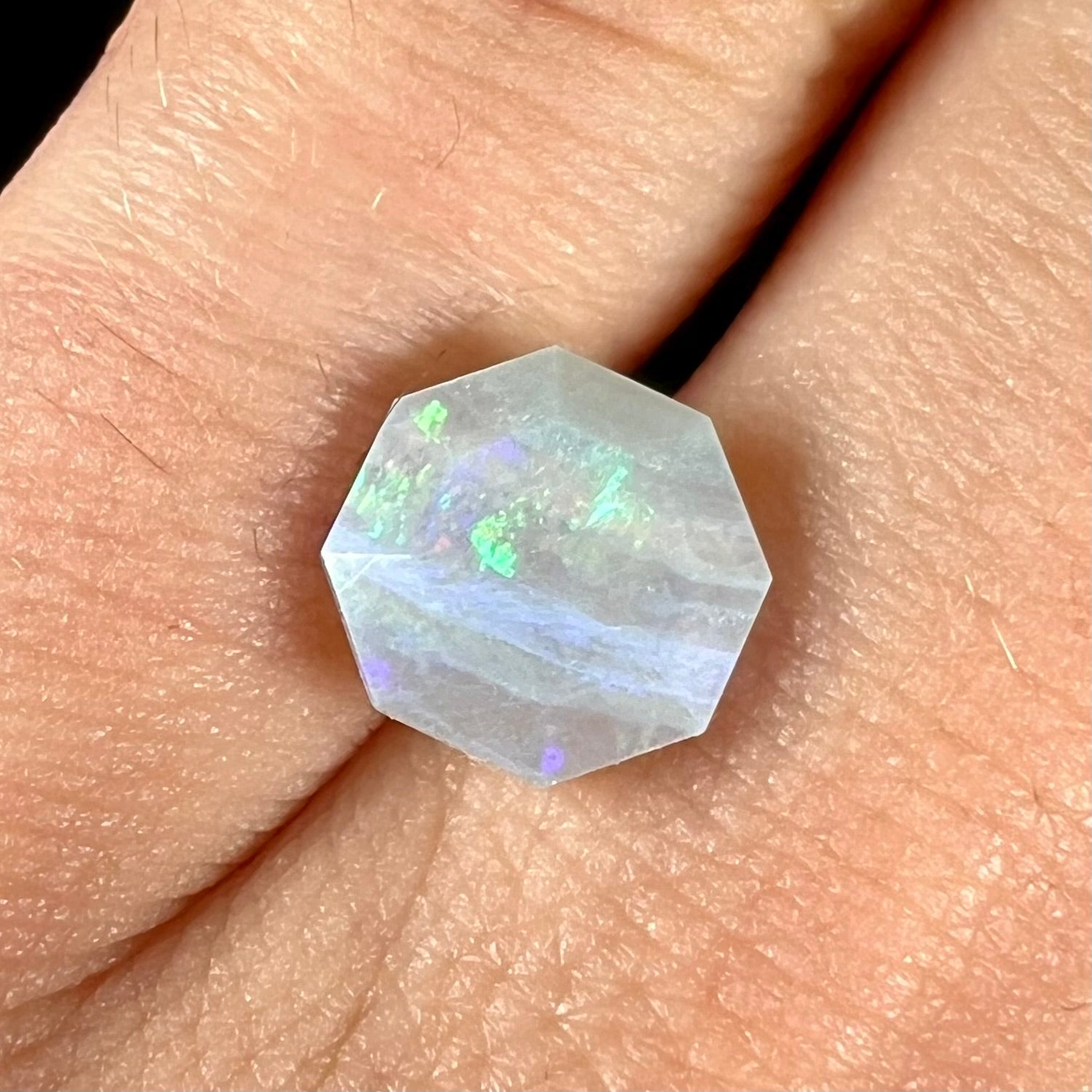 A loose, faceted octagon gray base crystal opal from Lightning Ridge, Australia.
