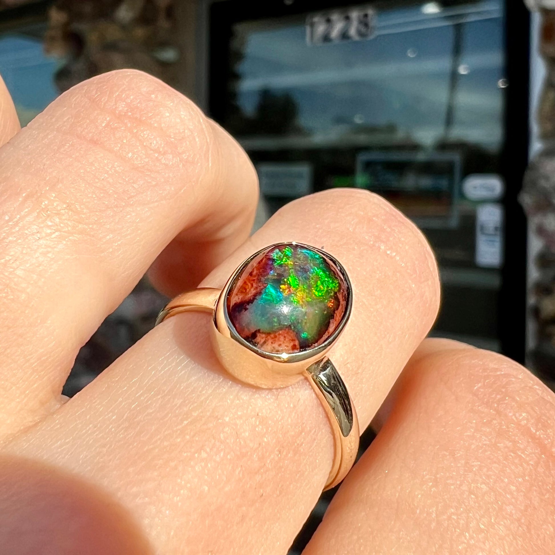 A ladies' yellow gold solitaire ring bezel set with an oval cabochon cut natural black Mexican cantera fire opal stone.