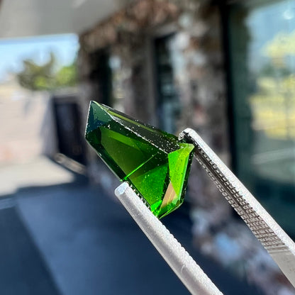 A freeform shield cut chrome diopside gemstone.