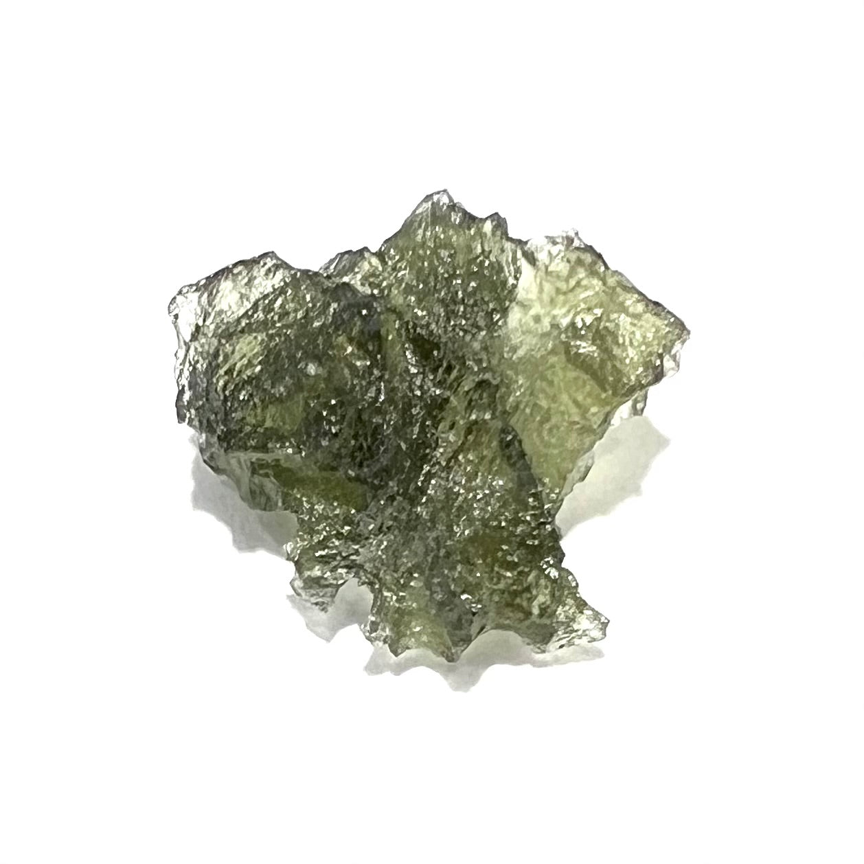 A natural, rough moldavite crystal.  The stone is green color and transluscent.