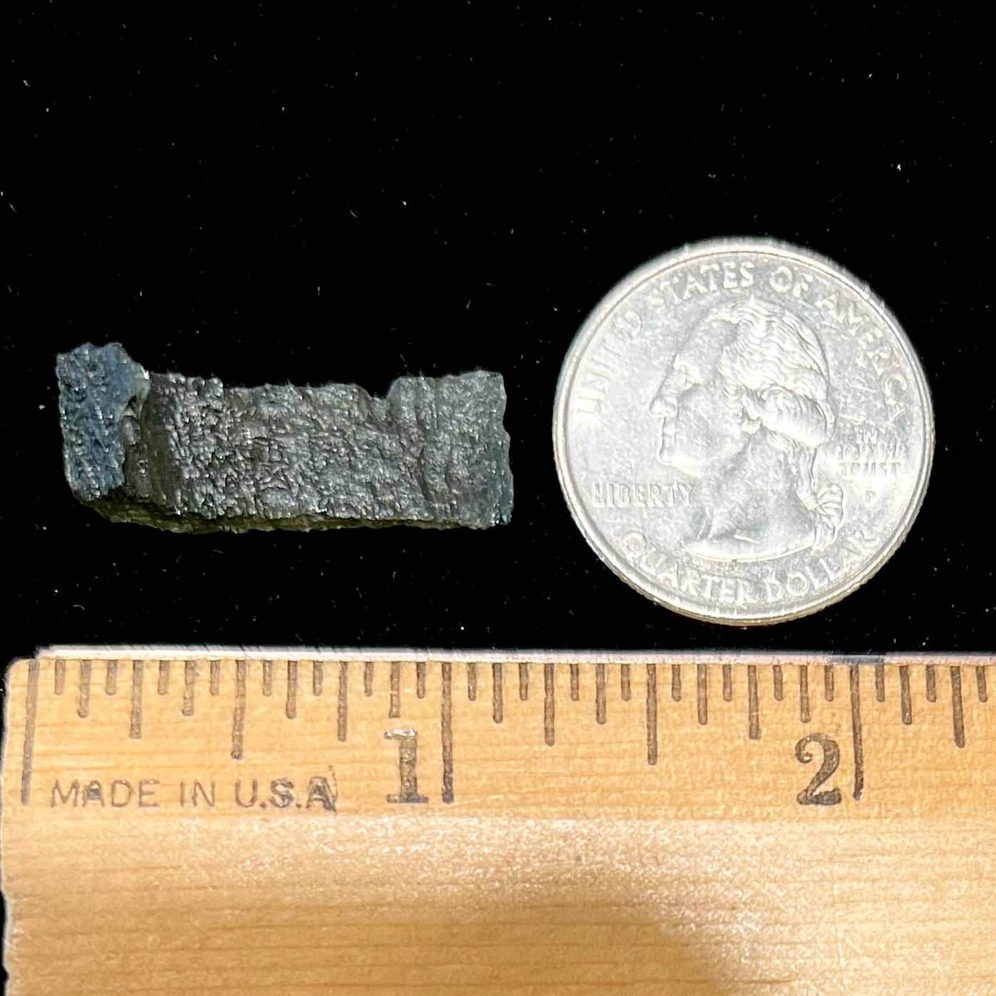 A natural, rough moldavite crystal.  The stone is shaped like the Nike Swoosh logo.