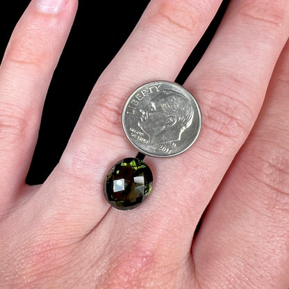 A loose, oval cut natural moldavite gemstone.  The stone weighs 3.85 carats.