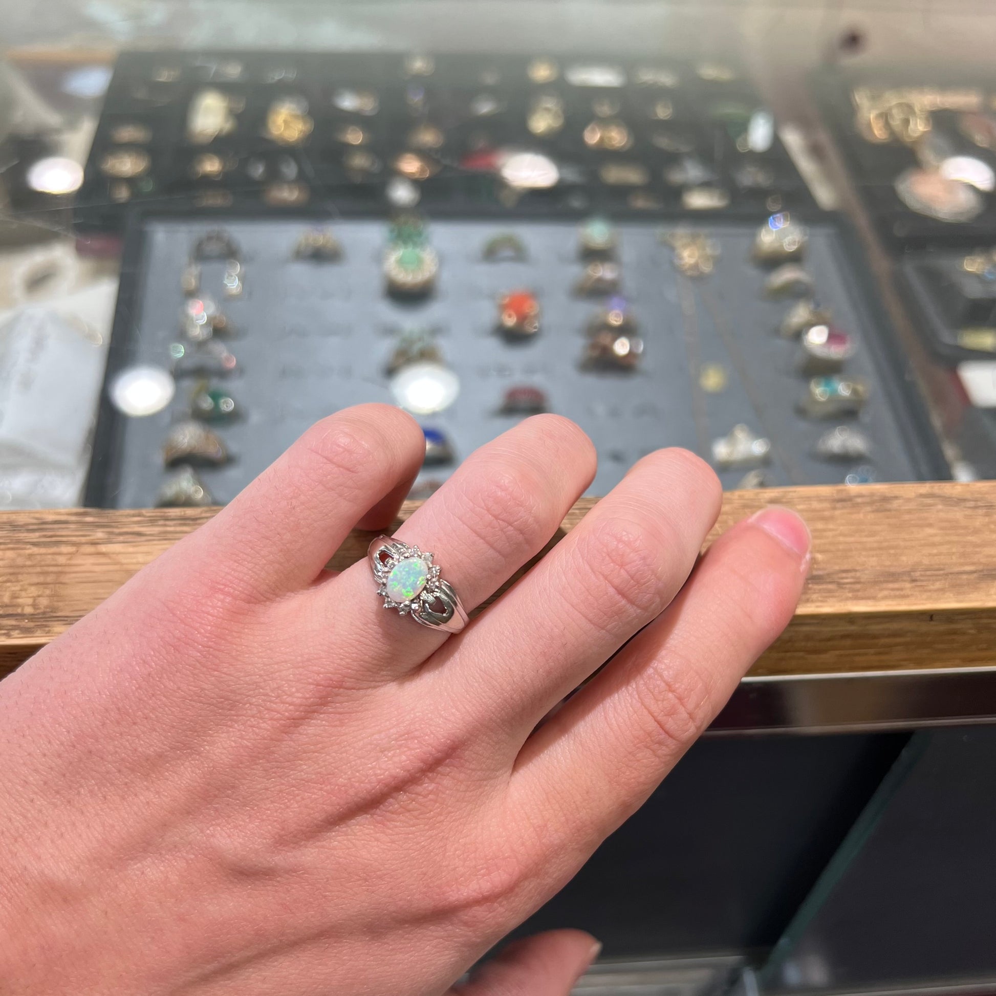 A ladies' white gold ring set with a halo of diamonds and an oval cabochon cut Australian opal.