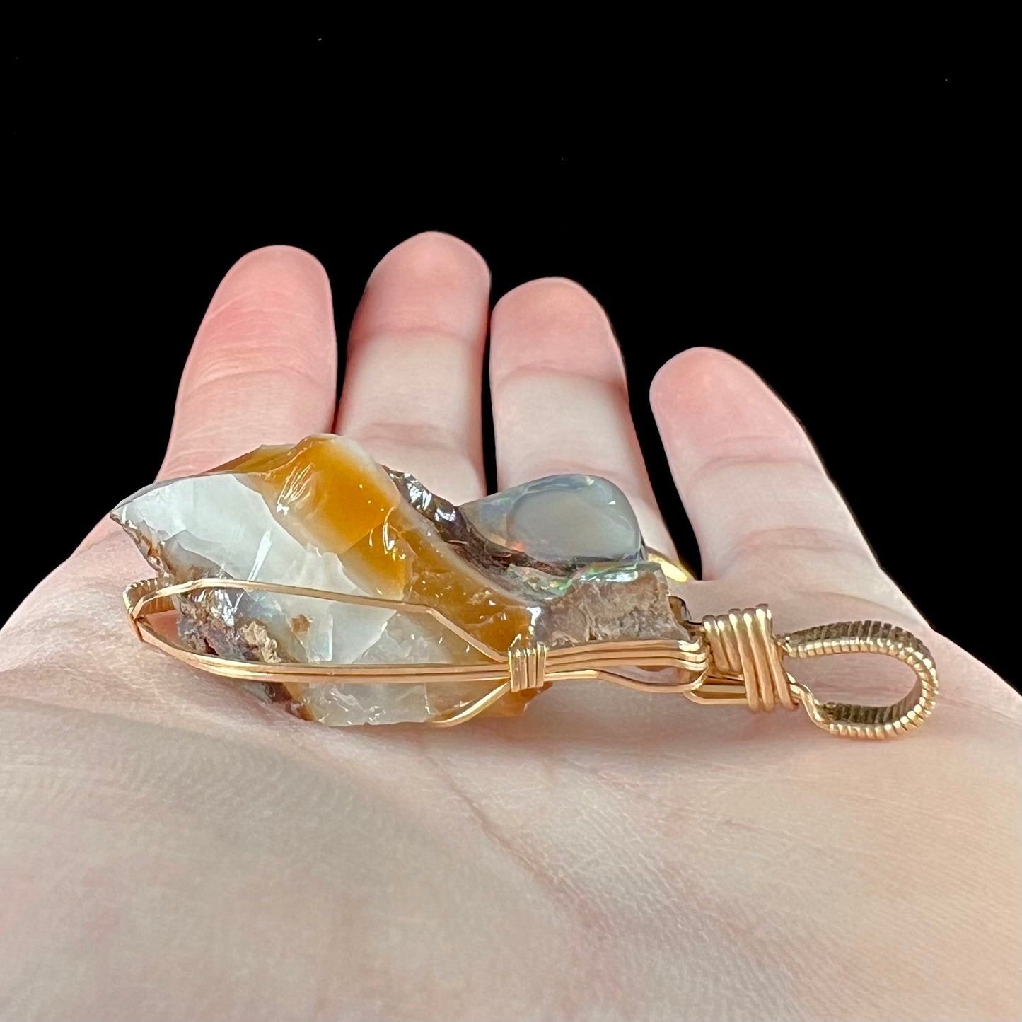 A gold filled wire wrapped pendant set with a natural Virgin Valley, Nevada opal crystal.
