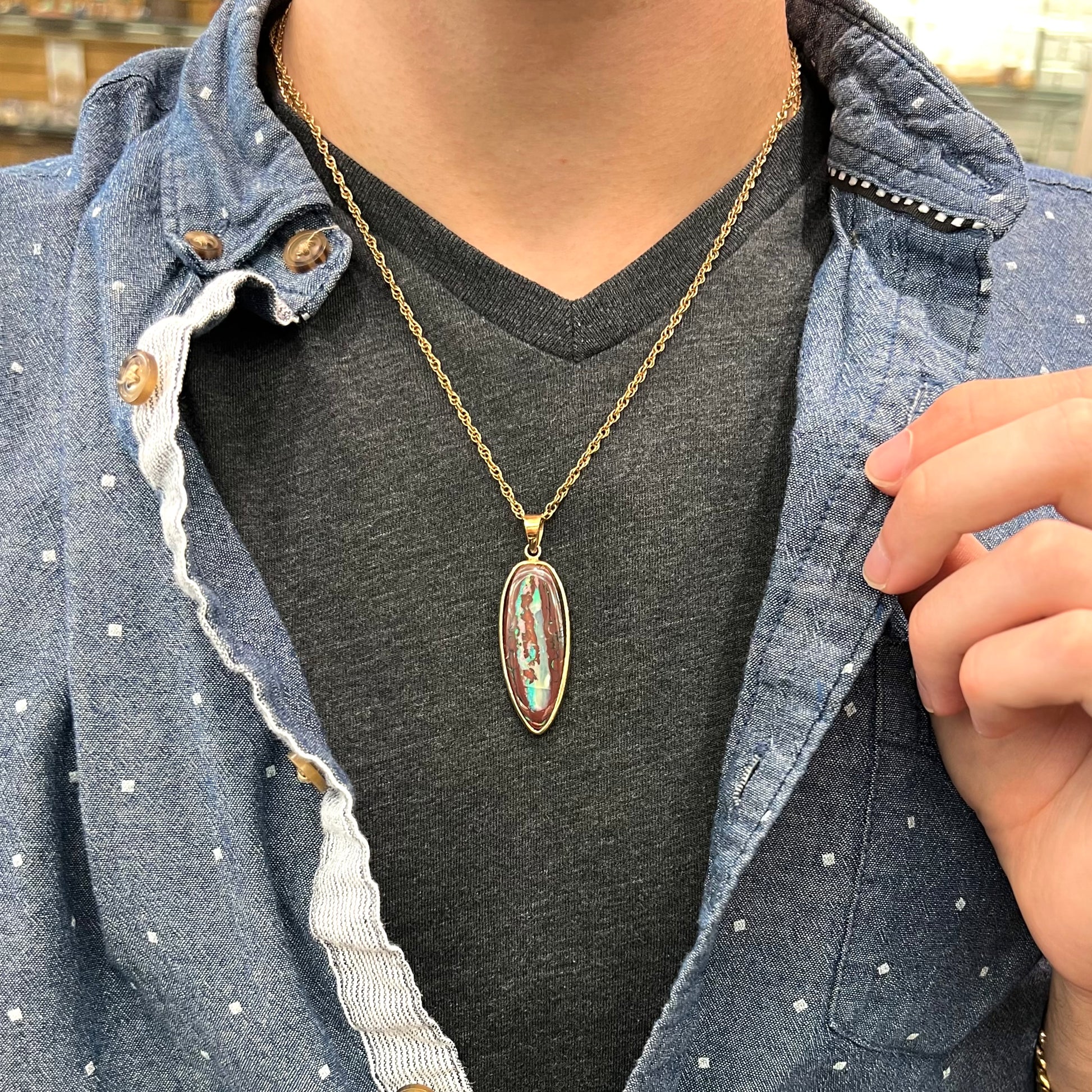 A yellow gold pendant set with a natural Yowah nut boulder opal stone.