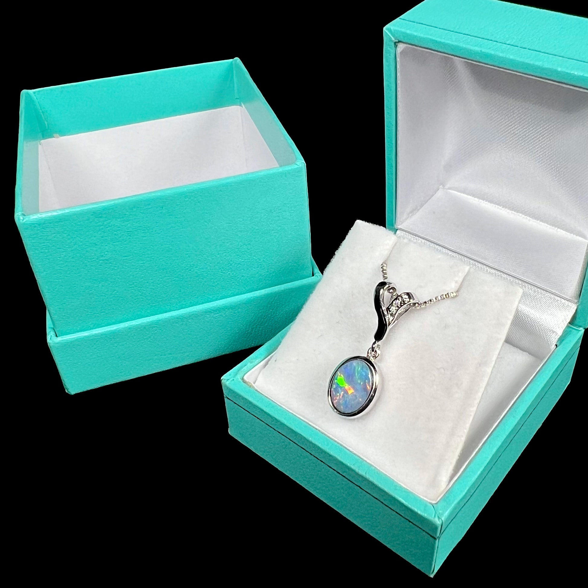 A sterling silver necklace set with a natural black opal doublet and white zircon accent stones.