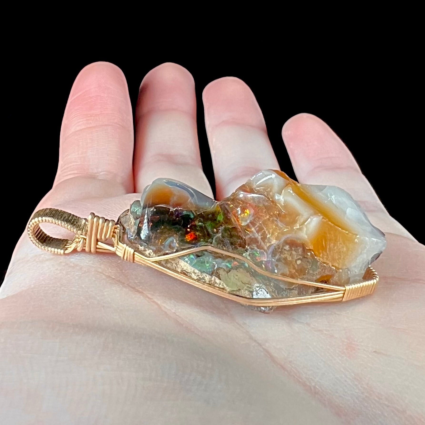 A gold filled wire wrapped pendant set with a natural Virgin Valley, Nevada opal crystal.