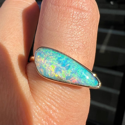 A ladies yellow gold solitaire ring bezel set with a natural opalized seashell from Coober Pedy, Australia.