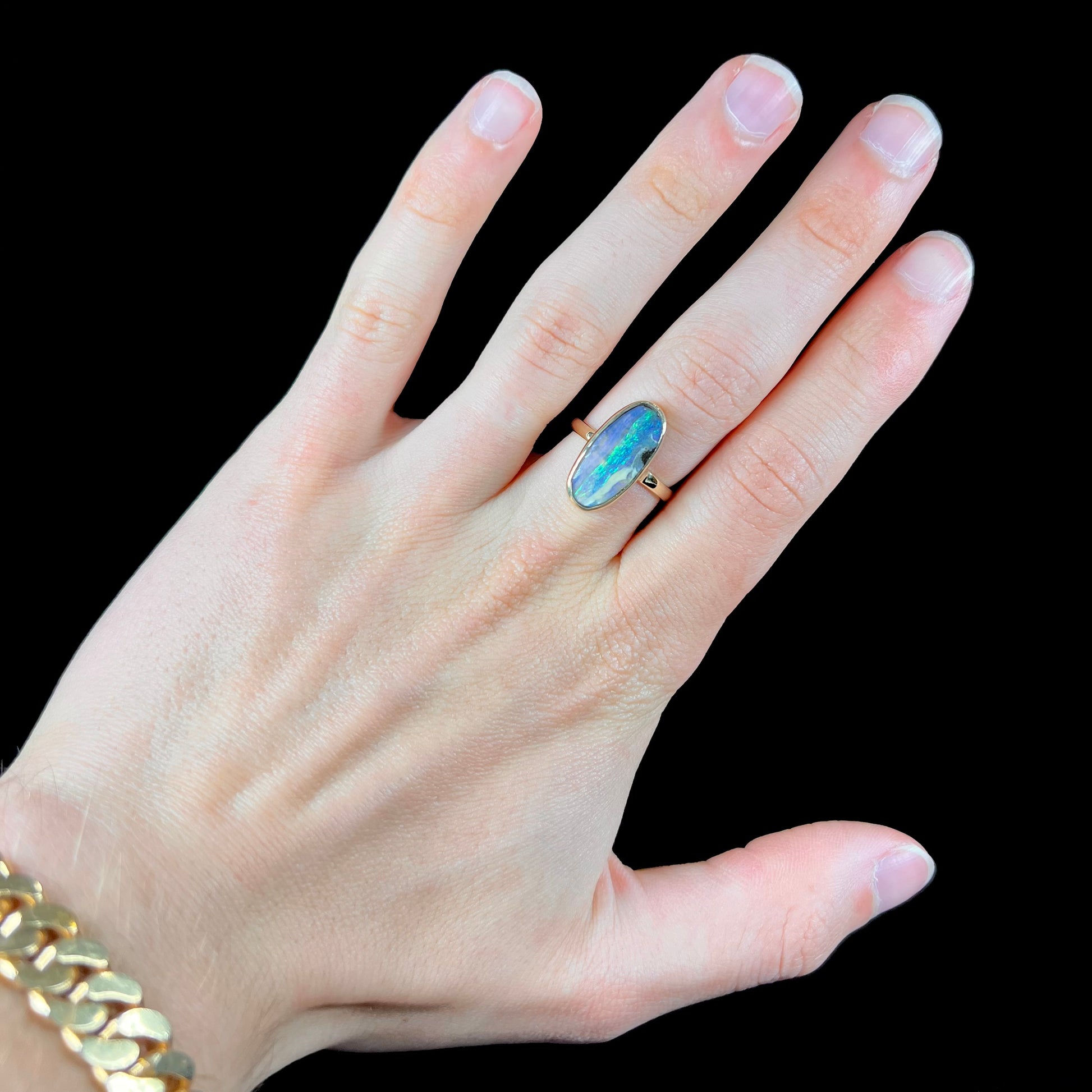 Ladies' yellow gold solitaire ring bezel set with a natural green striped boulder opal from Quilpie, Australia.