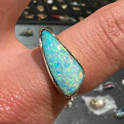 A ladies yellow gold solitaire ring bezel set with a natural opalized seashell from Coober Pedy, Australia.