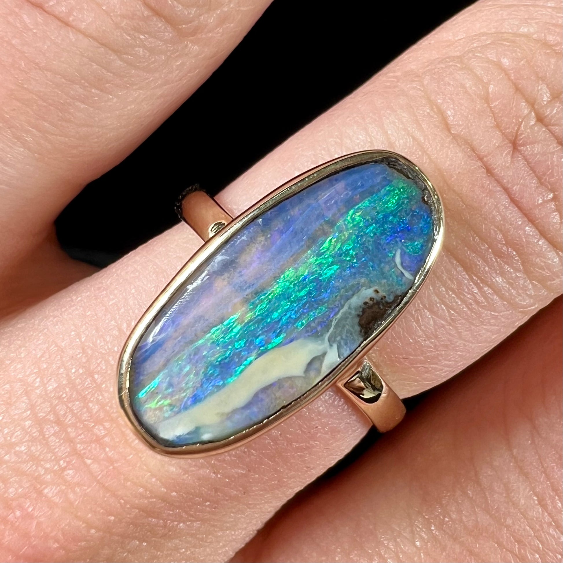Ladies' yellow gold solitaire ring bezel set with a natural green striped boulder opal from Quilpie, Australia.