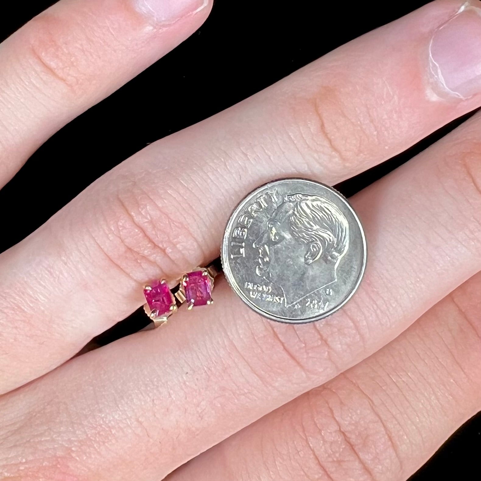 A pair of yellow gold stud earrings set with pinkish red Burmese rubies.  The rubies are emerald cut.