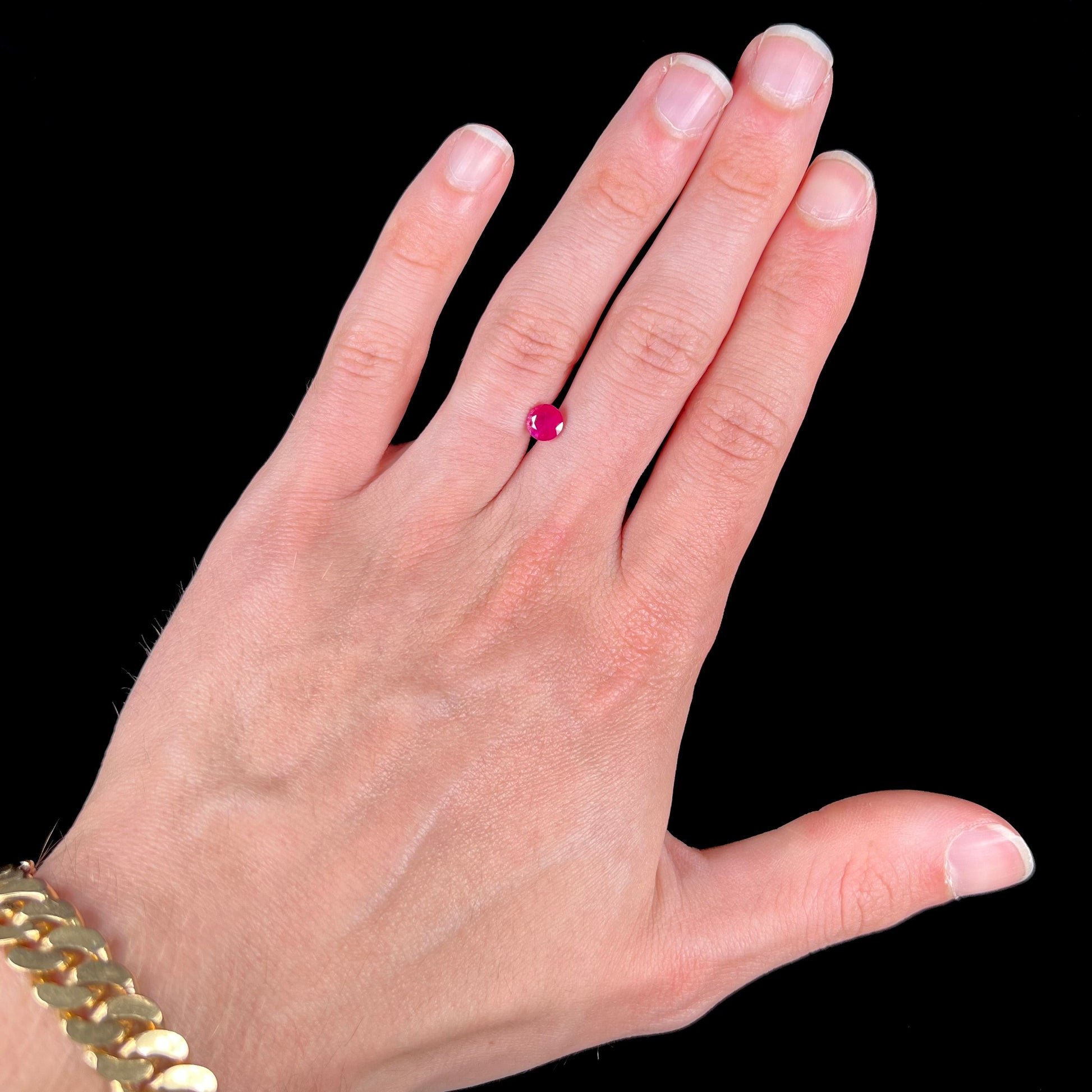 A faceted round brilliant cut Burma ruby gemstone.  The stone is certified as natural by Guild Laboratories.