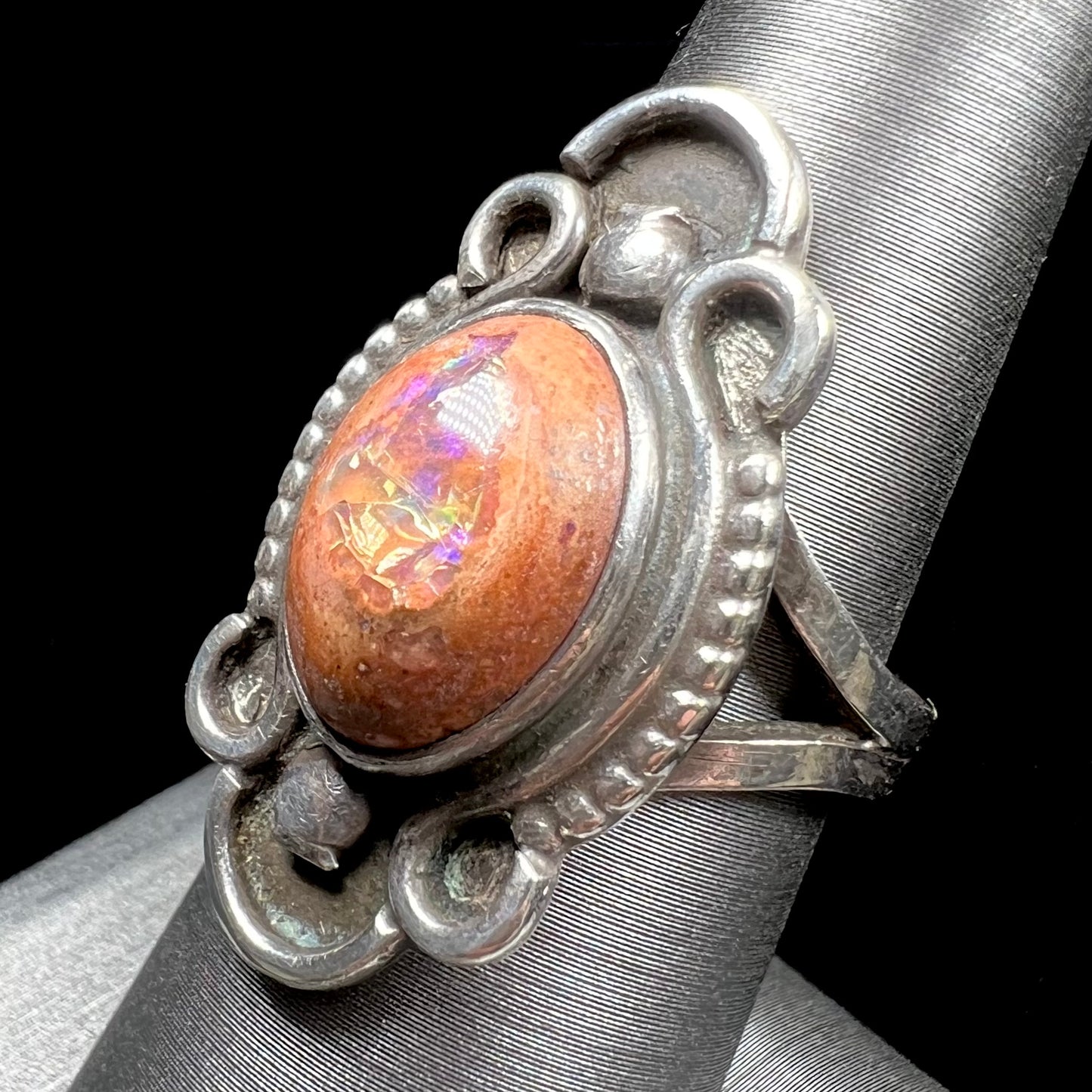 A vintage, Navajo style sterling silver ring set with an oval cabochon cut cantera fire opal stone.