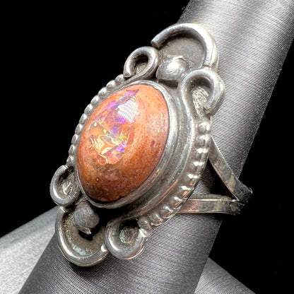A vintage, Navajo style sterling silver ring set with an oval cabochon cut cantera fire opal stone.