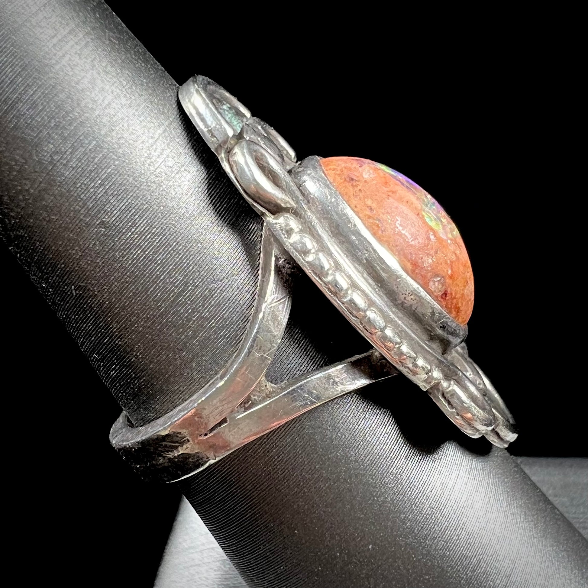A vintage, Navajo style sterling silver ring set with an oval cabochon cut cantera fire opal stone.