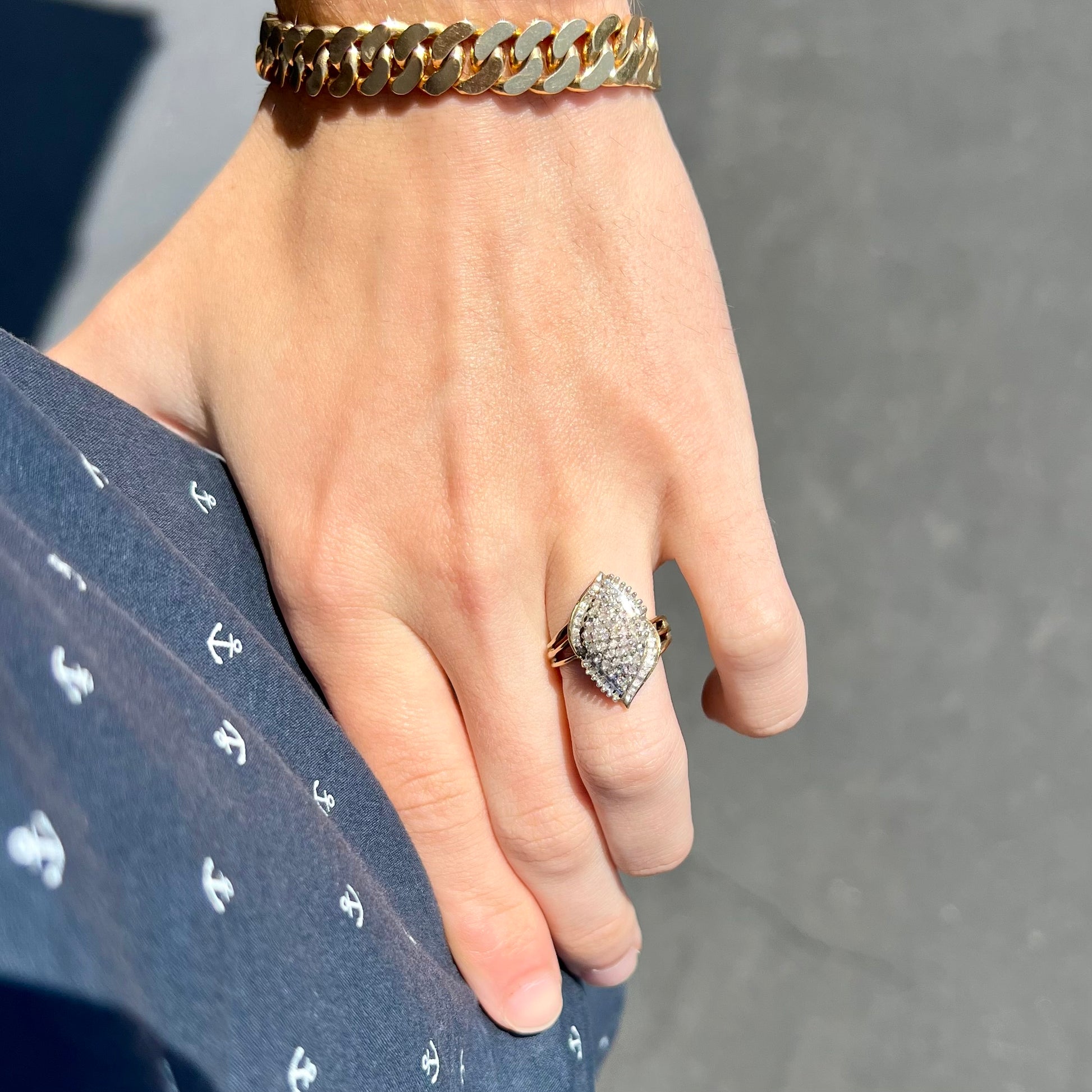 A ladies' yellow gold and diamond cluster ring.  The diamonds are round and baguette shaped, and the ring is navette shaped.