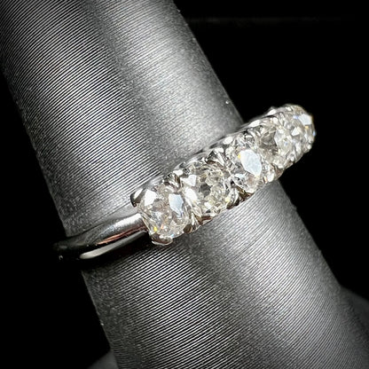 An antique white gold diamond wedding band set with six old mine cut natural diamonds.