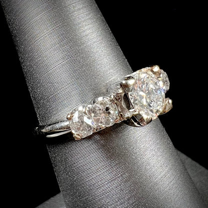 A ladies' 1800's antique white gold diamond ring.  The center stone is an Early American Cut diamond, and the accent stones are Old Mine Cut diamonds.