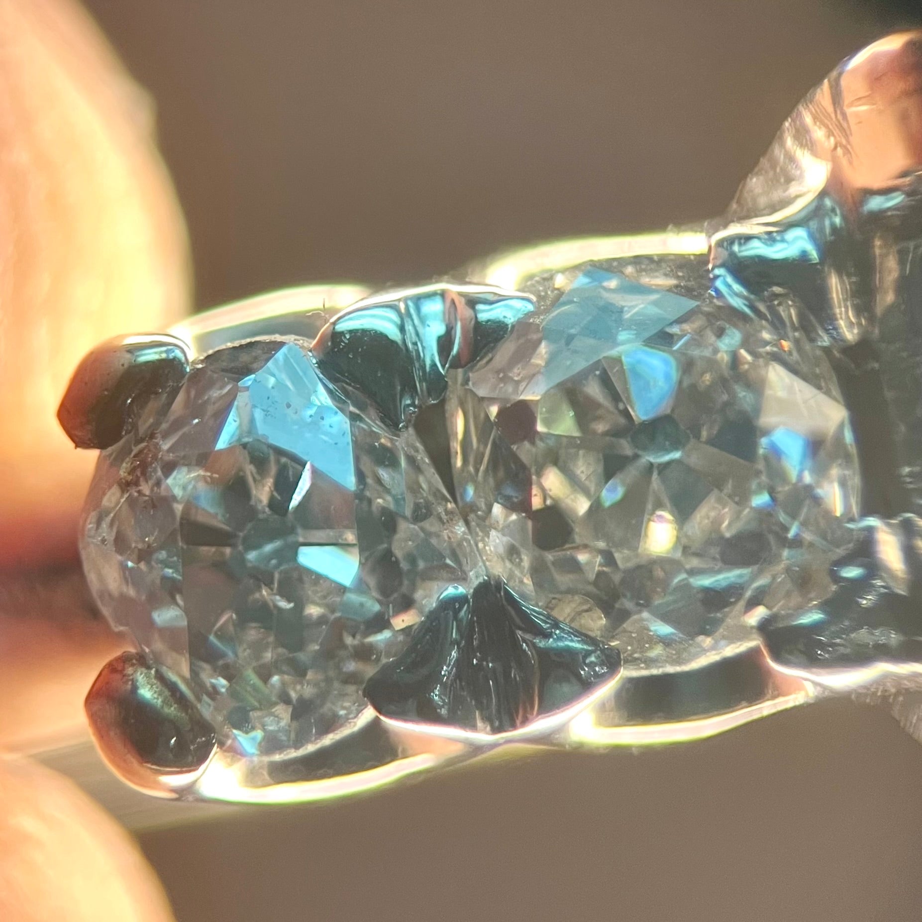 A ladies' 1800's antique white gold diamond ring.  The center stone is an Early American Cut diamond, and the accent stones are Old Mine Cut diamonds.