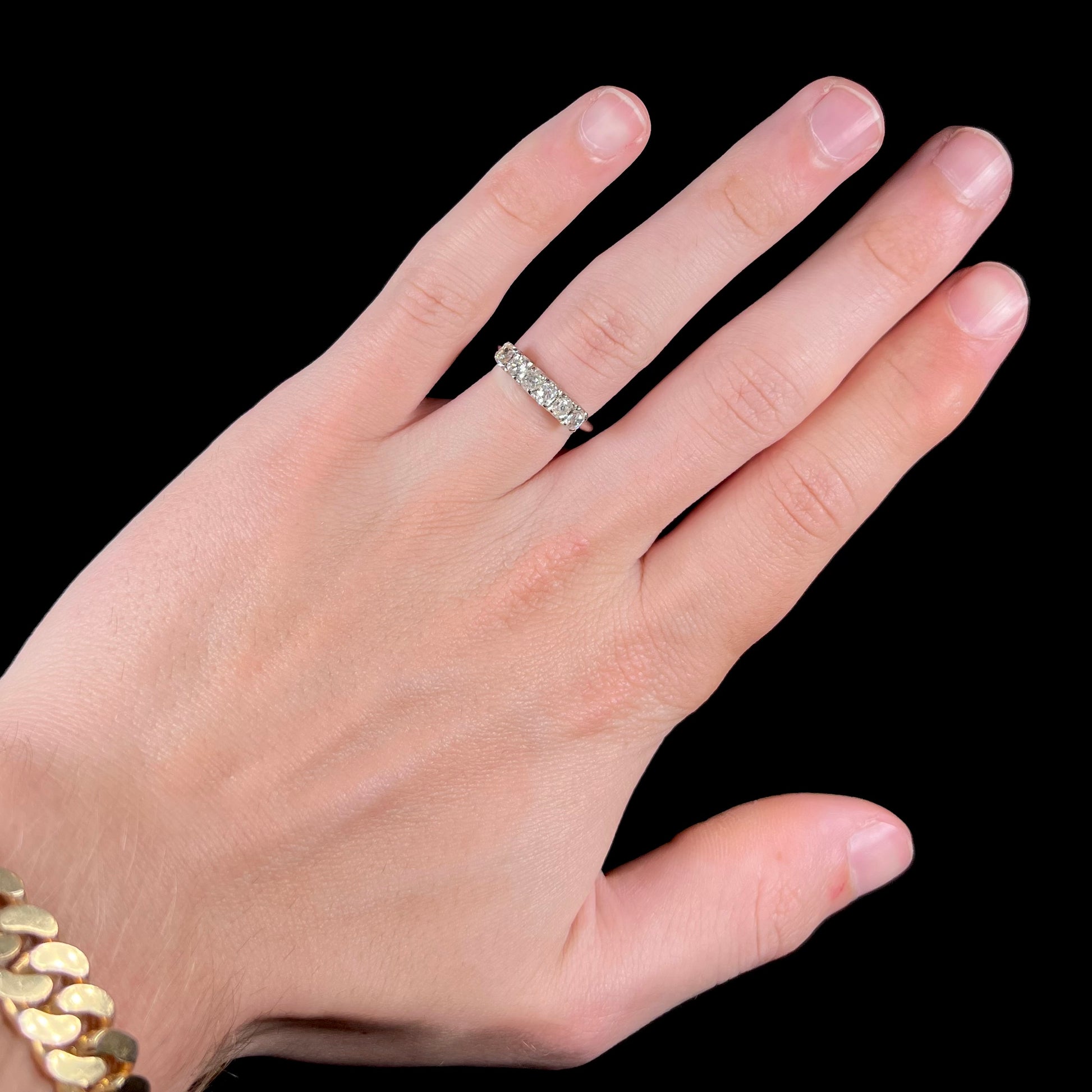 An antique white gold diamond wedding band set with six old mine cut natural diamonds.