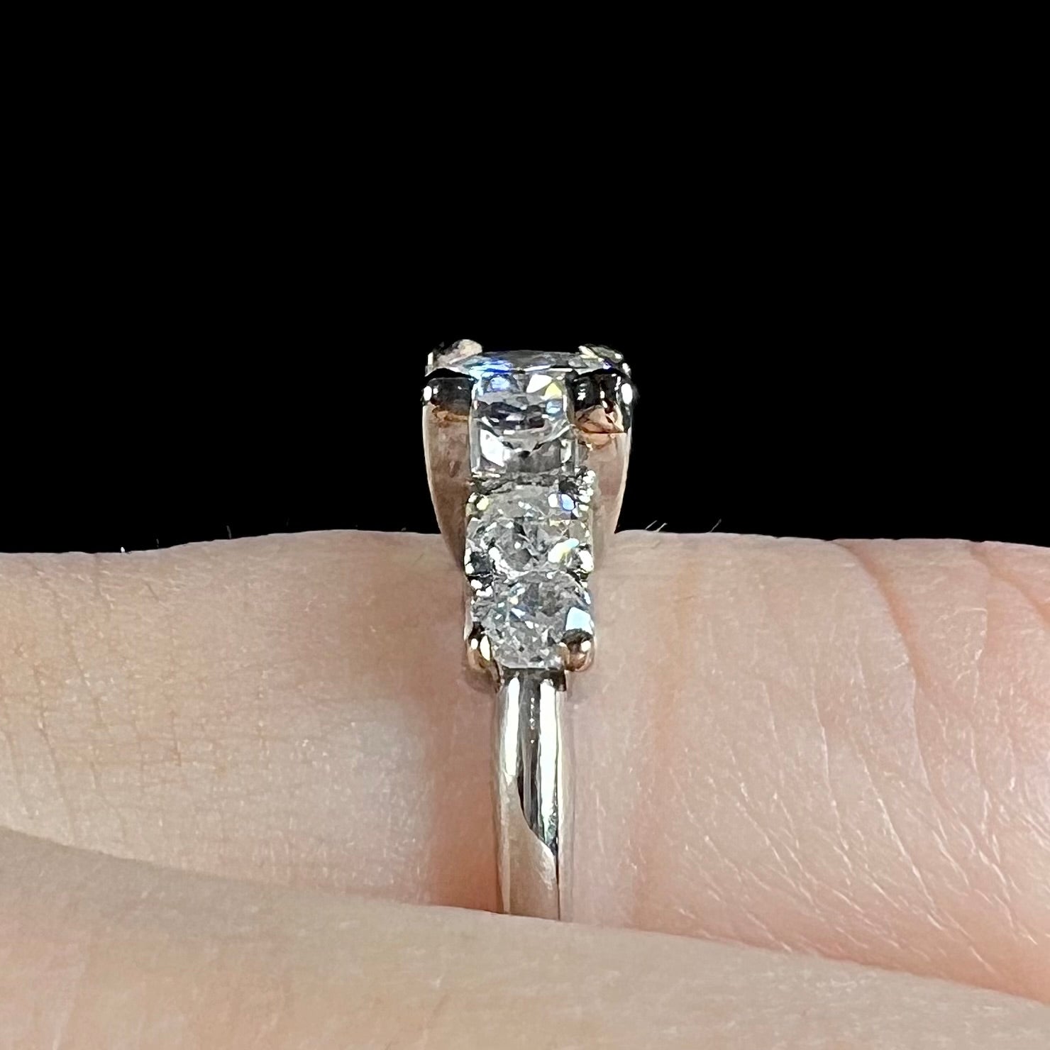 A ladies' 1800's antique white gold diamond ring.  The center stone is an Early American Cut diamond, and the accent stones are Old Mine Cut diamonds.