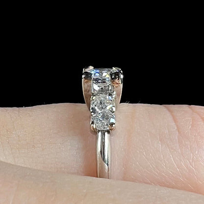 A ladies' 1800's antique white gold diamond ring.  The center stone is an Early American Cut diamond, and the accent stones are Old Mine Cut diamonds.