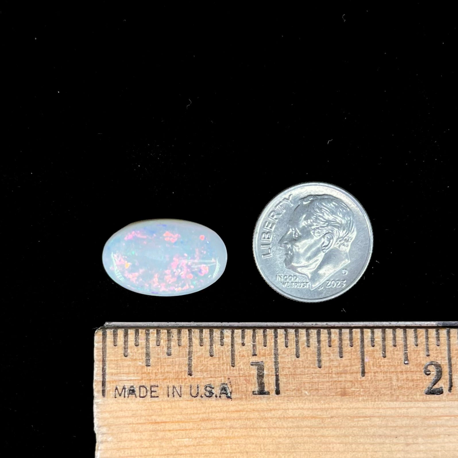 An oval cabochon cut opal from Coober Pedy, Australia.  The opal has predominantly red fire.