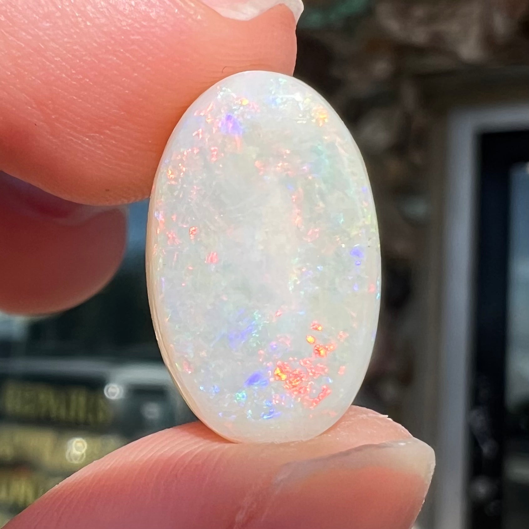 An oval cabochon cut opal from Coober Pedy, Australia.  The opal has predominantly red fire.