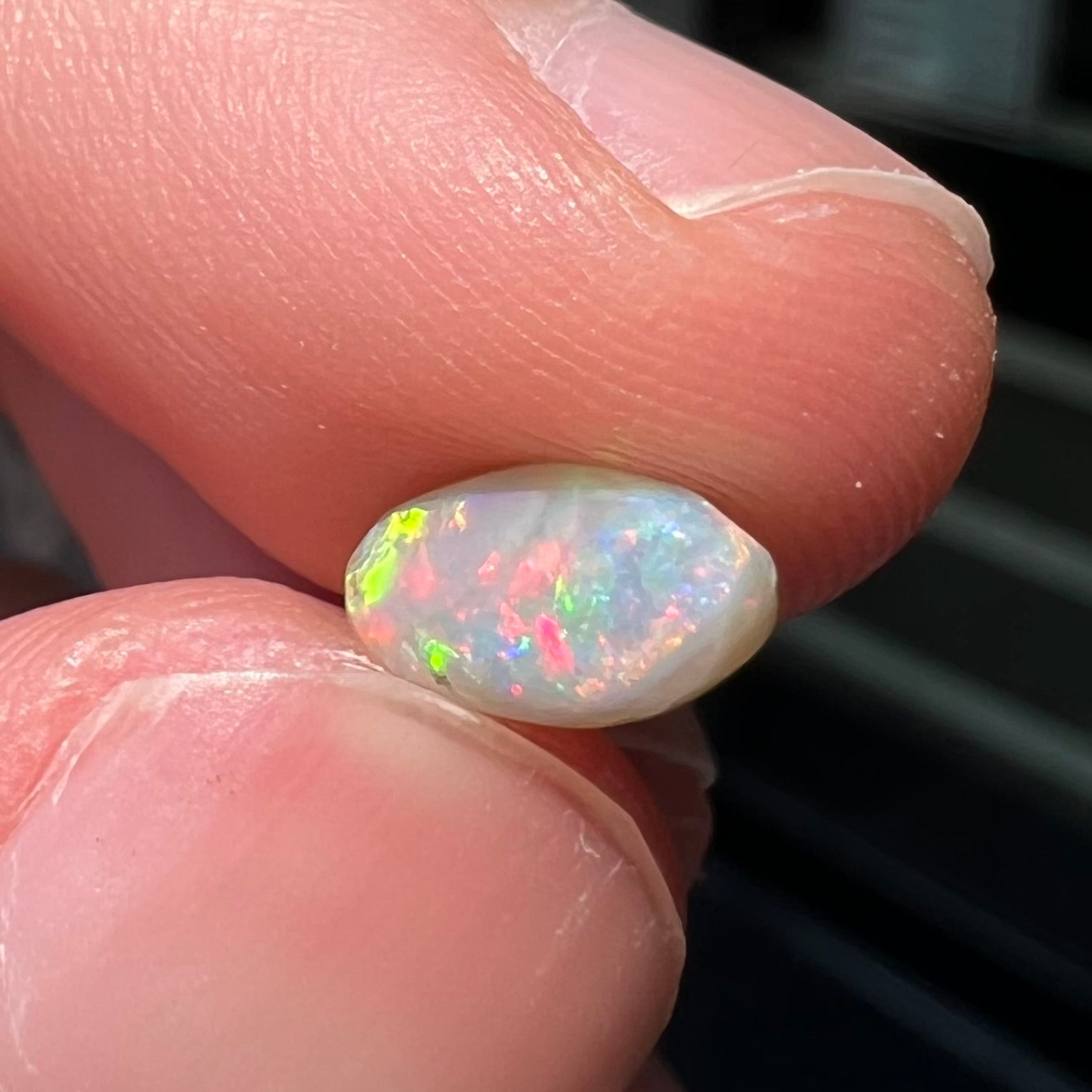 A loose, light opal from Lightning Ridge, Australia.  The opal shines a rainbow of colors.