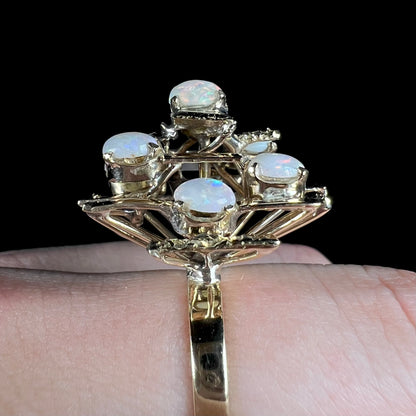 A Mid-Century Modern gold opal cluster ring.  The ring has a tall, tree-like structure and is set with seven natural opals.