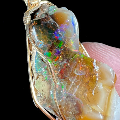 A gold filled wire wrapped pendant set with a natural Virgin Valley, Nevada opal crystal.