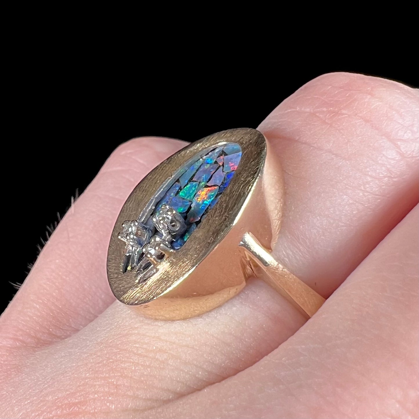 A vintage mosaic opal ring set with diamond accents in 10 karat yellow and white gold.
