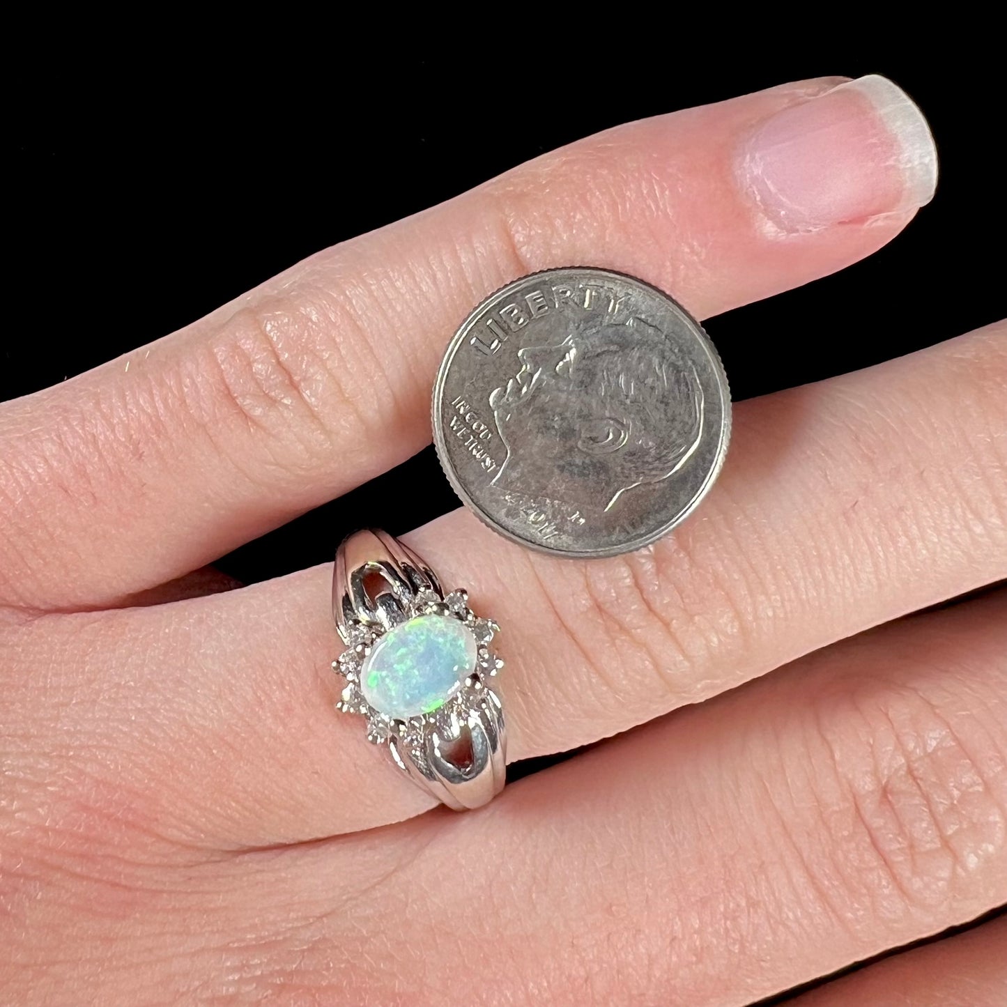 A ladies' white gold ring set with a halo of diamonds and an oval cabochon cut Australian opal.