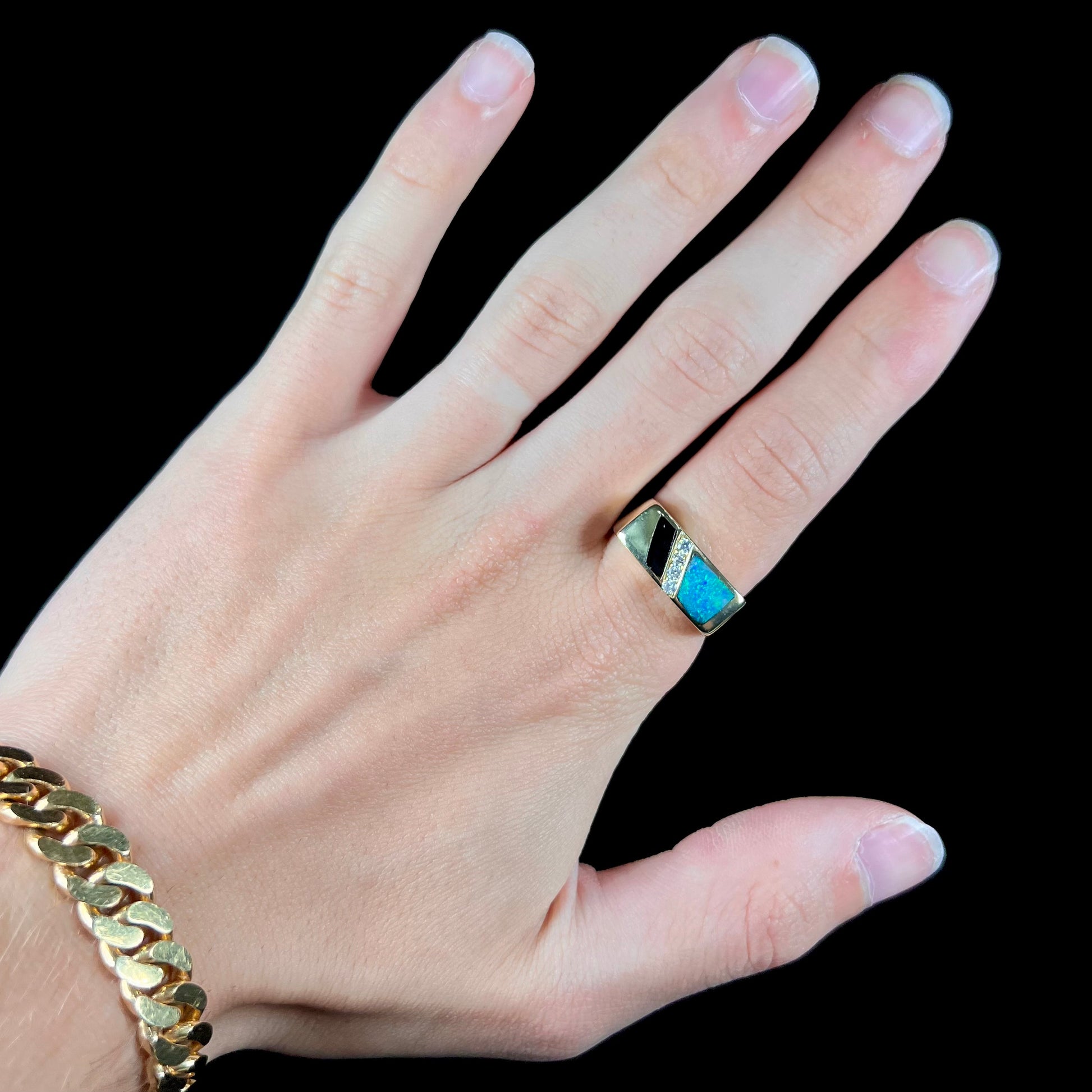 A men's yellow gold ring inlay set with onyx, natural black opal, and four diamonds.