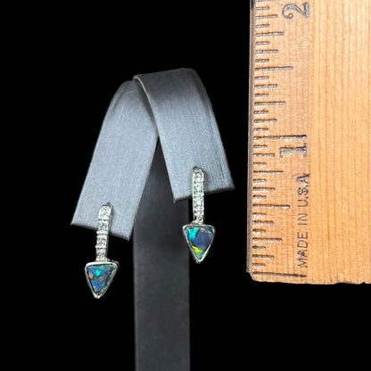 A white gold pendant and earrings set mounted with triangle cut natural black opals and diamonds.