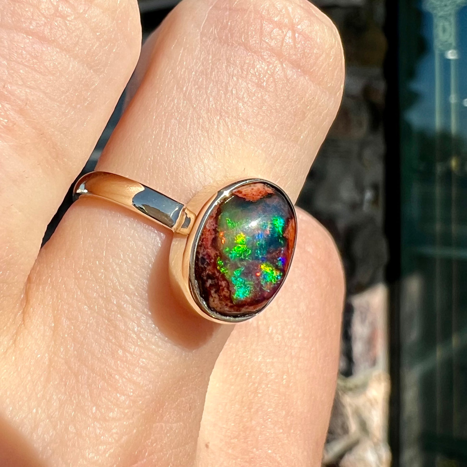 A ladies' yellow gold solitaire ring bezel set with an oval cabochon cut natural black Mexican cantera fire opal stone.